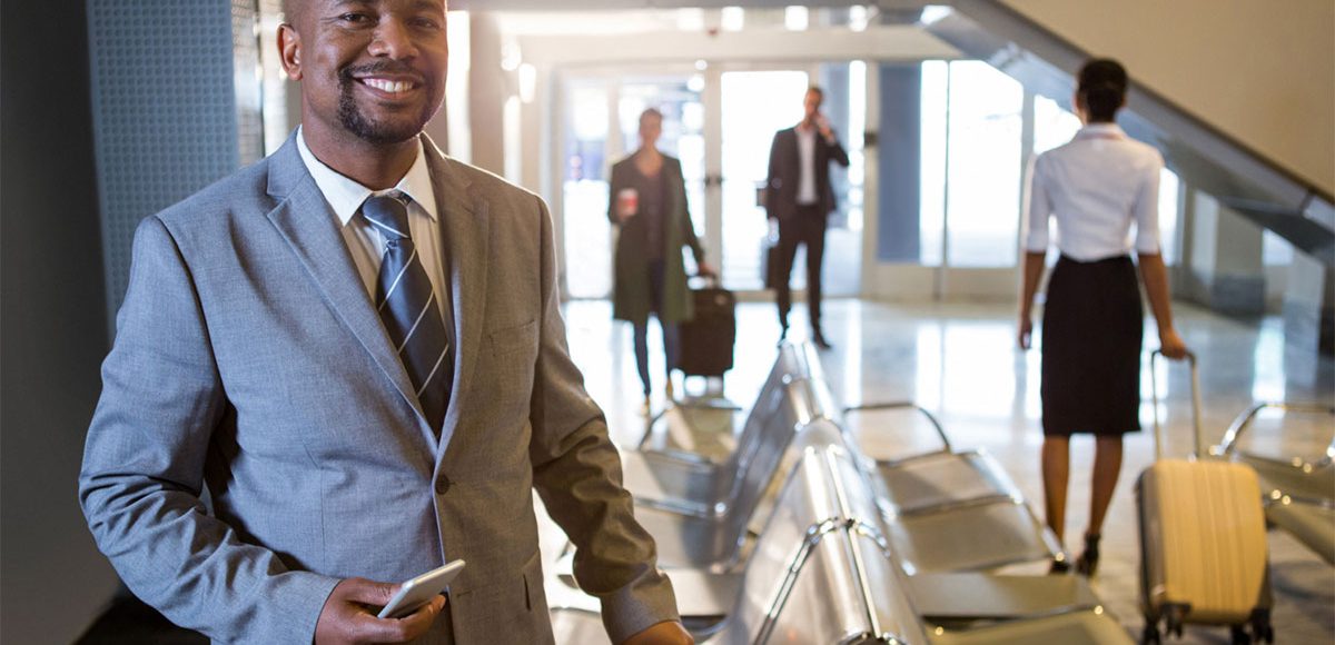 Man-smiling-holding-a-travel-bag